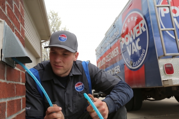 A Power Vac Technician cleaning a dryer vent.