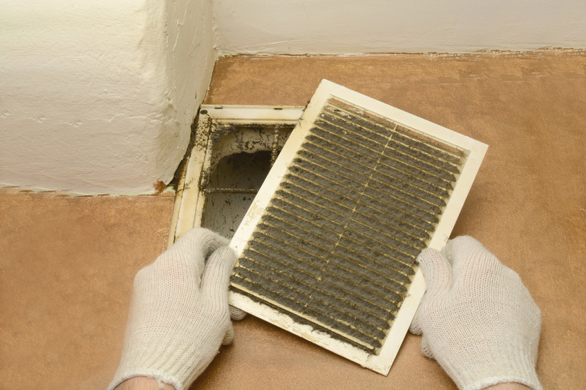 A dirty air duct cover being cleaned by Power Vac.